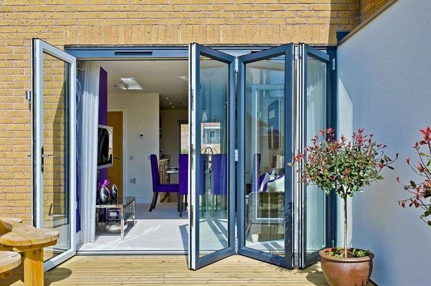 Modern aluminium bifold doors fully opened, creating a seamless connection between indoor and outdoor spaces with a sleek, space-saving design.