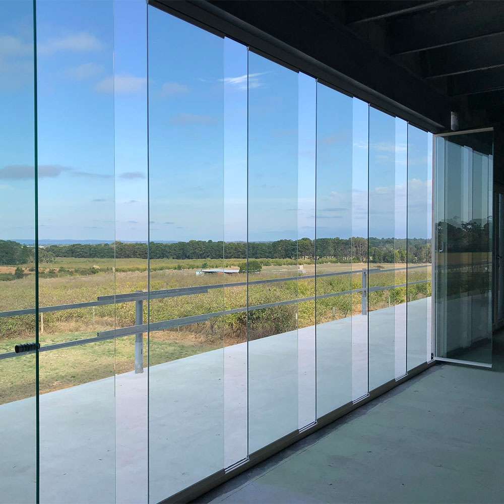 Frameless bi-fold glass doors in an office space