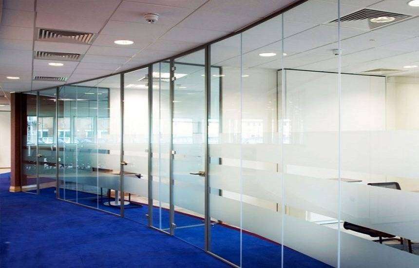 A modern office with smart switchable glass partitions, transitioning from clear to frosted with a simple switch for enhanced privacy and contemporary aesthetics.