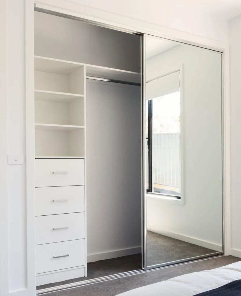 A sliding cupboard door with a sleek, reflective mirror finish.