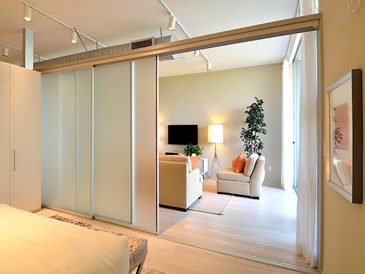 A modern sliding partition door separating a living and dining space.