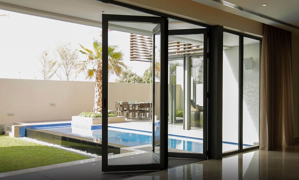 Professional installation of aluminium bifold doors in Dubai showing certified technicians installing German Schuco system in luxury villa