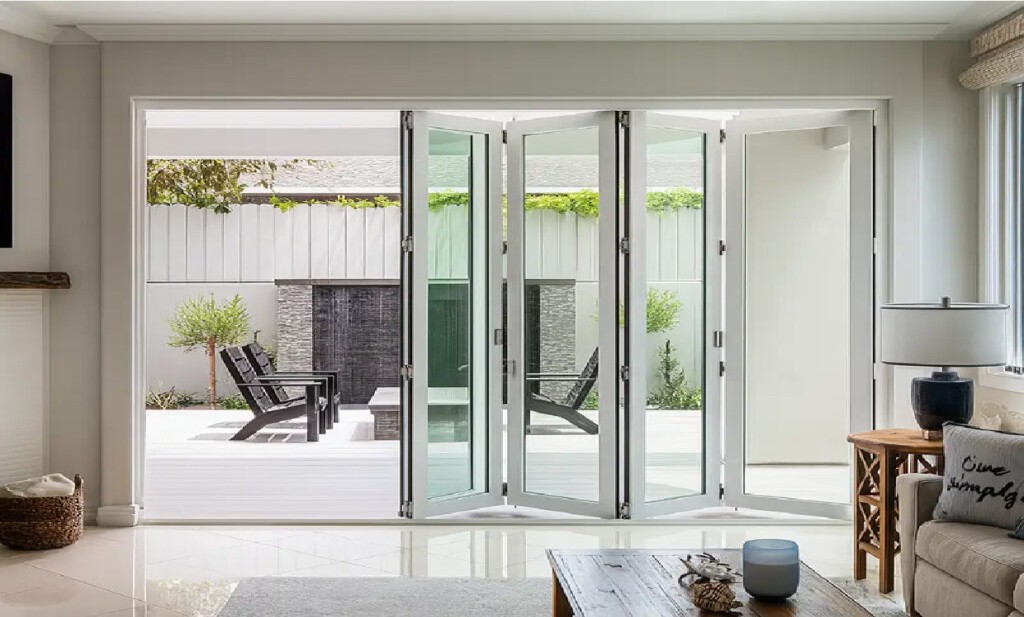 Professional folding door installation process showing technician installing multi-panel system with precision leveling and alignment in Dubai property